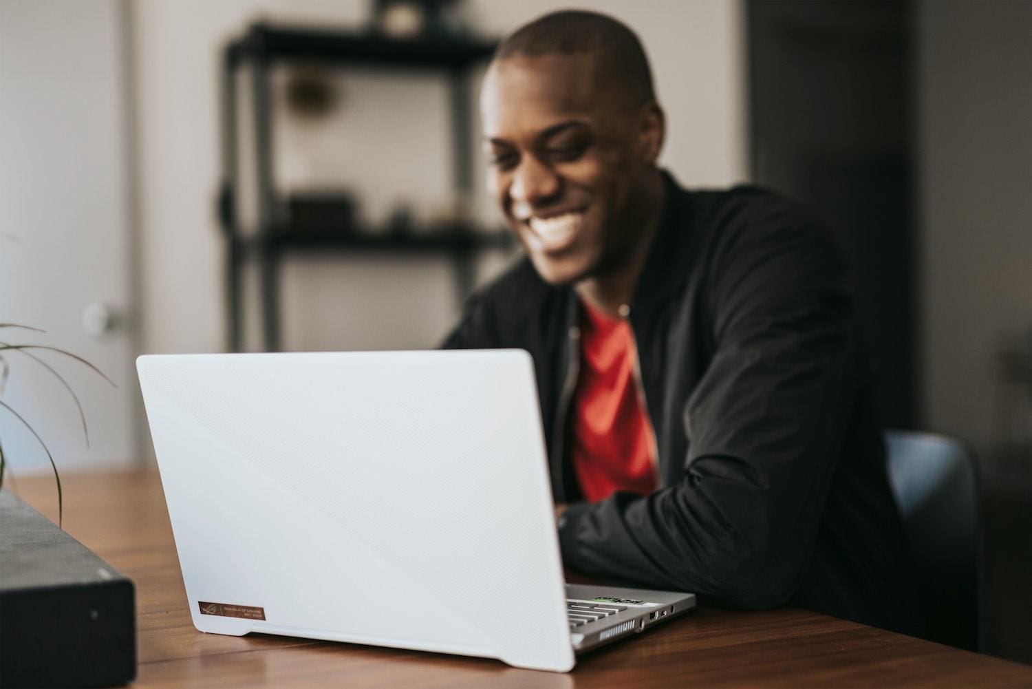man smiling at laptop
